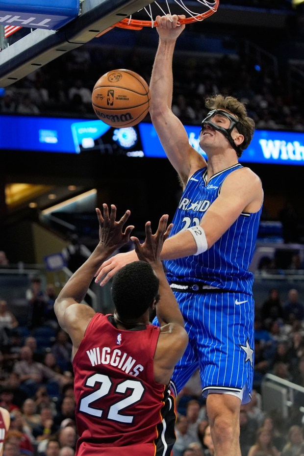 Orlando Magic forward Franz Wagner, right, dunks over Miami Heat forward Andrew Wiggins (22) during the second half of an NBA basketball game, Friday, Dec. 5, 2025, in Orlando, Fla. (AP Photo/John Raoux)