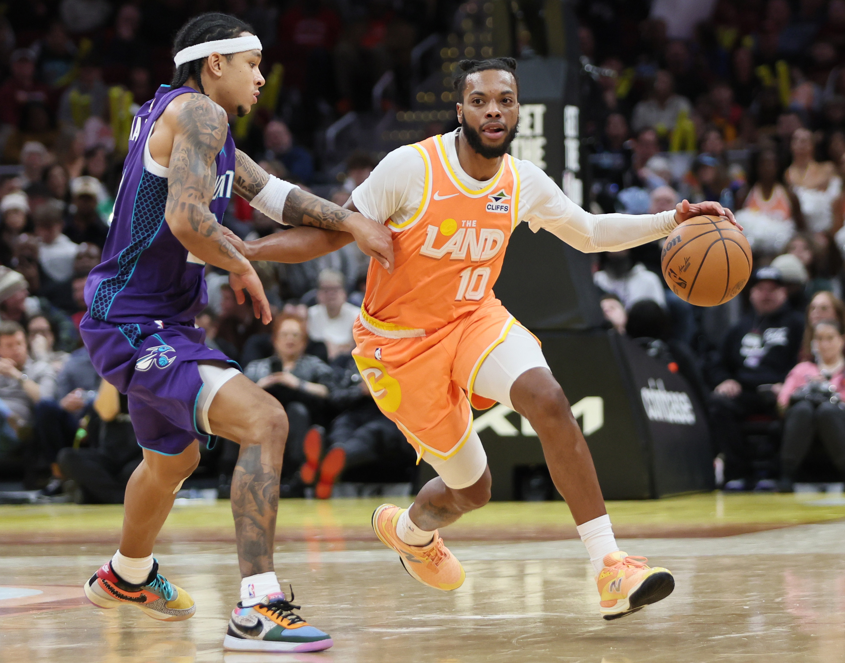 Cleveland Cavaliers guard Darius Garland brings the basketball up court guarded by Charlotte Hornets guard Tre Mann in the second half at Rocket Arena.