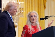 President Donald Trump listens as Miriam Adelson speaks during a Hanukkah reception in the...