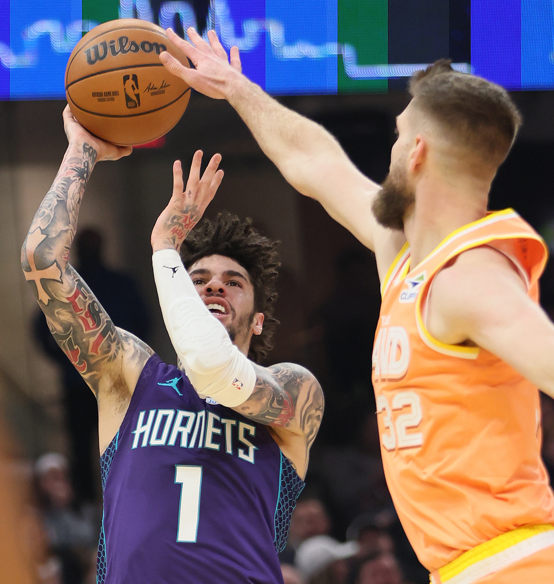 Charlotte Hornets guard Lamelo Ball takes a running jump shot attempt guarded by Cleveland Cavaliers forward Dean Wade in the first half at Rocket Arena. 