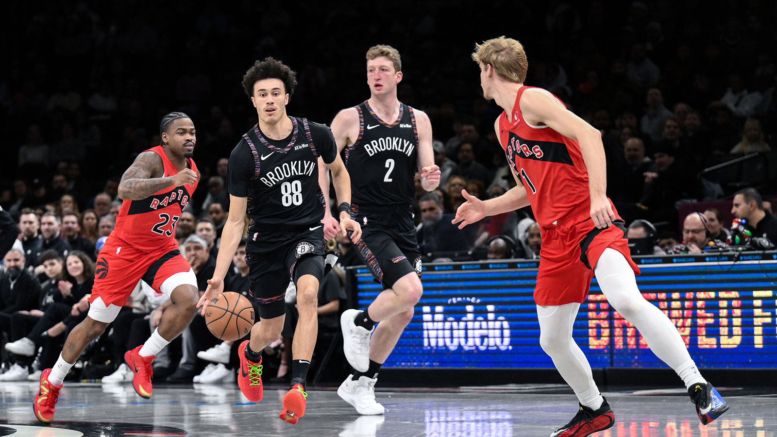 Brooklyn Nets guard Nolan Traore (88) brings the ball up court while defended by Toronto Raptors guard/forward Gradey Dick (1) during the first half at Barclays Center.