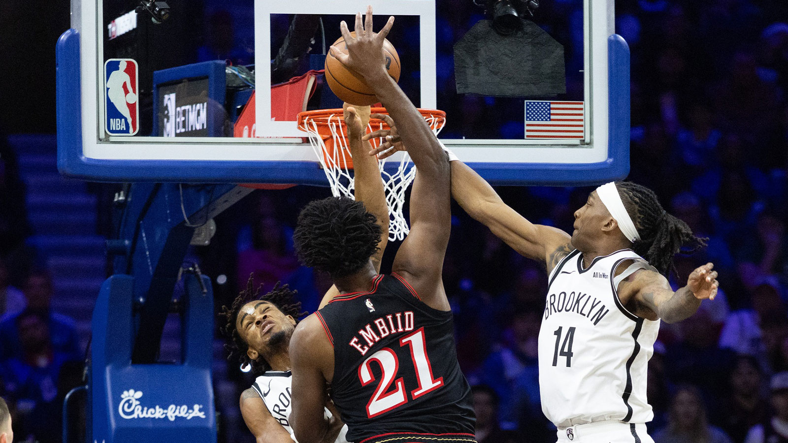 Philadelphia 76ers center Joel Embiid (21) is fouled while driving against Brooklyn Nets guard Terance Mann (14) and center Nic Claxton (33) during the second quarter at Xfinity Mobile Arena.