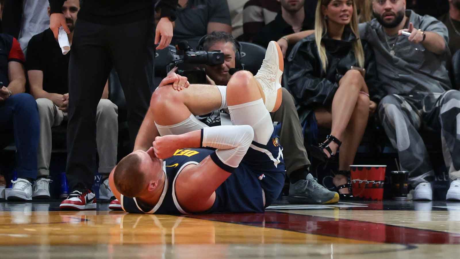 Denver Nuggets center Nikola Jokic (15) holds his knee after an injury against the Miami Heat during the second quarter at Kaseya Center.