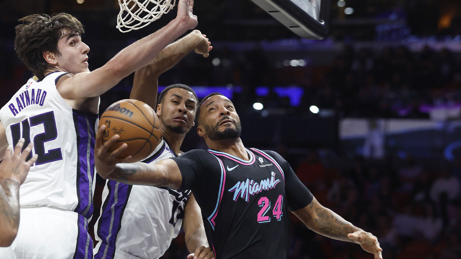 Miami Heat guard Norman Powell (24) shoots between Sacramento Kings center Maxime Raynaud (42) and forward Keegan Murray (13) during the first half at Kaseya Center.