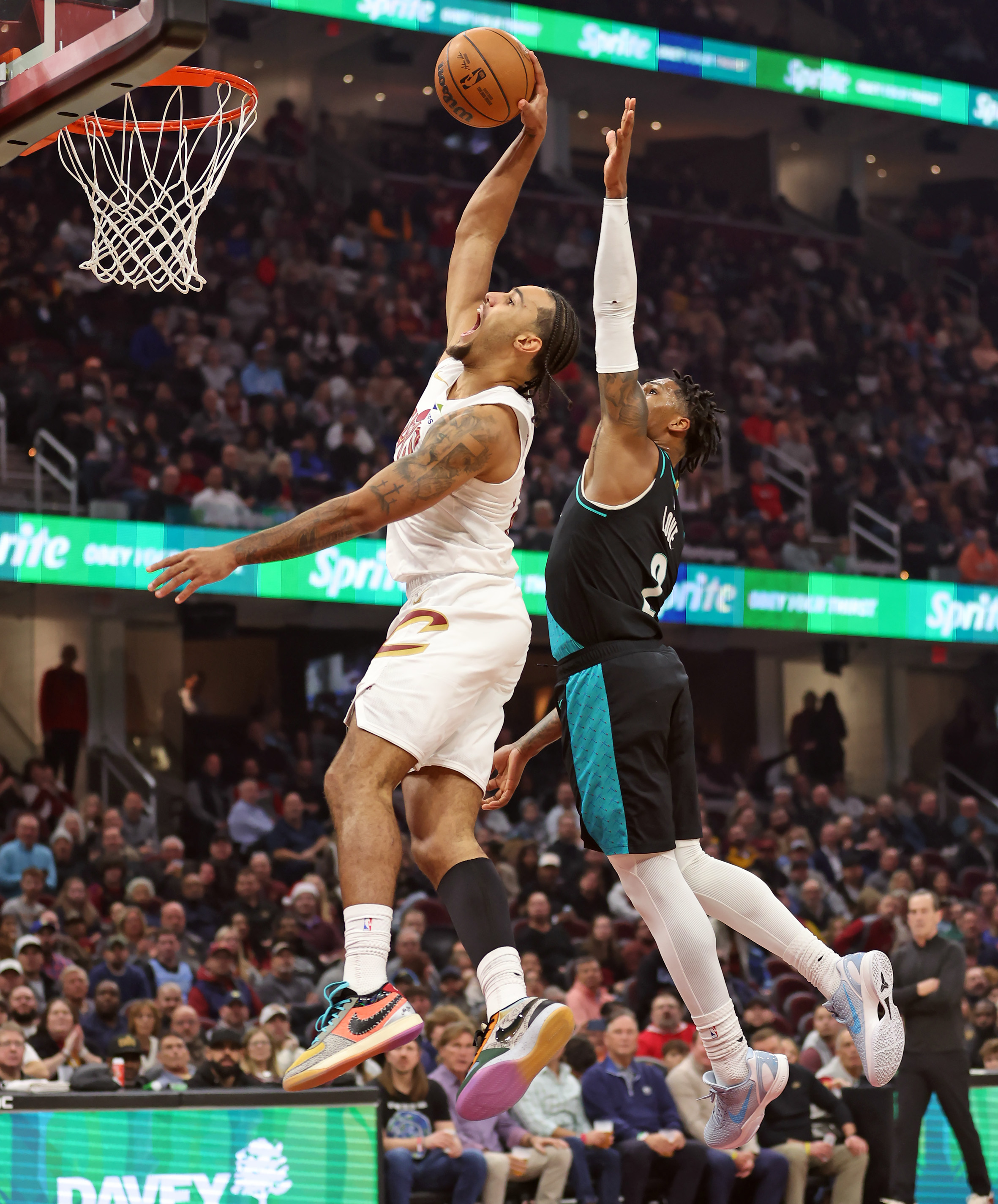 Cleveland Cavaliers guard Jaylon Tyson beats Portland Trail Blazers guard Caleb Love to the rim for a dunk in the first half of play. 