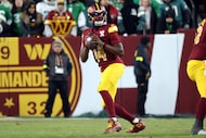 Washington Commanders quarterback Josh Johnson (14) sets to throw the ball during an NFL...