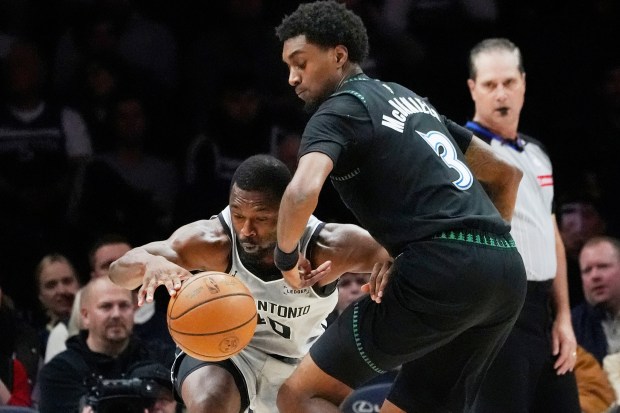 Minnesota Timberwolves forward Jaden McDaniels, right, defends against San Antonio Spurs forward Harrison Barnes (40) in the first quarter of an NBA basketball game Sunday, Nov. 30, 2025, in Minneapolis. (AP Photo/Bruce Kluckhohn)
