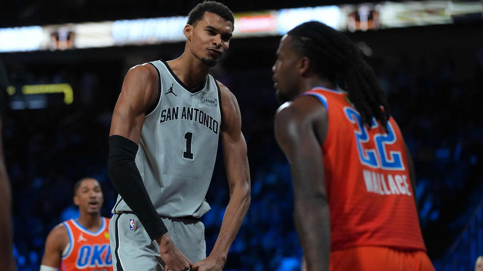 San Antonio Spurs forward Victor Wembanyama (1) flexes in front of Oklahoma City Thunder guard Cason Wallace (22) during the third quarter at T-Mobile Arena.