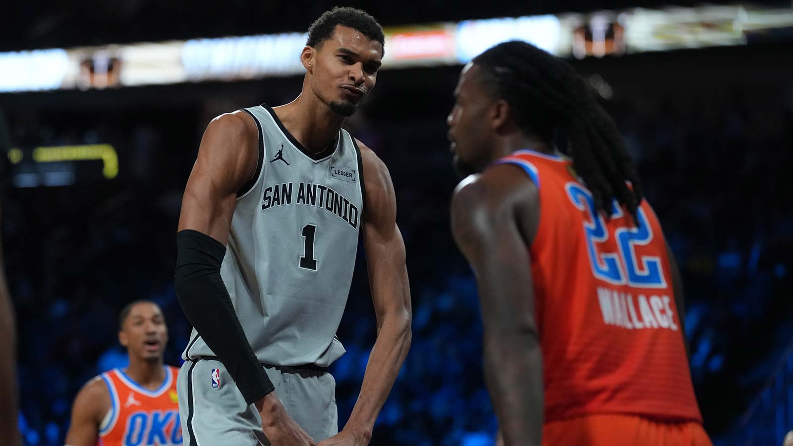 Spurs forward Victor Wembanyama (1) flexes in front of Oklahoma City Thunder guard Cason Wallace (22) during the third quarter at T-Mobile Arena