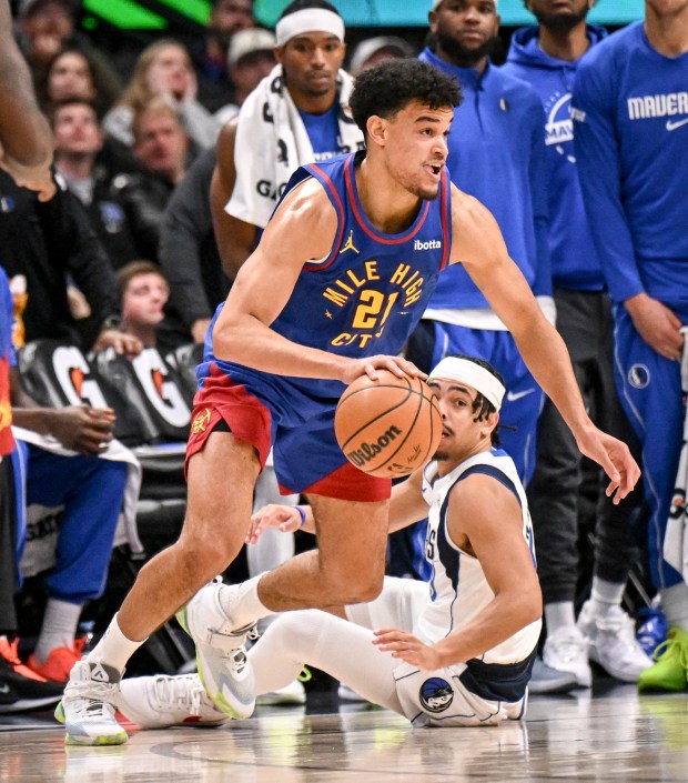 DENVER , CO - DECEMBER 1: Spencer Jones (21) of the Denver Nuggets handles the ball after beating Ryan Nembhard (9) of the Dallas Mavericks to it during the fourth quarter at Ball Arena in Denver, Colorado on Monday, December 1, 2025. (Photo by AAron Ontiveroz/The Denver Post)