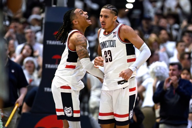UConn guard Solo Ball celebrates with UConn forward Jayden Ross (23) in the second half of an NCAA college basketball game against Butler, Tuesday, Dec. 16, 2025, in Hartford, Conn. (AP Photo/Jessica Hill)