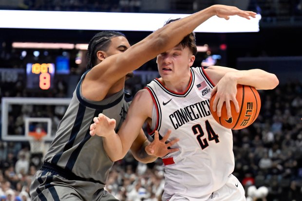 UConn guard Braylon Mullins (24) drives to the basket as Butler guard Yame Butler defends in the second half of an NCAA college basketball game, Tuesday, Dec. 16, 2025, in Hartford, Conn. (AP Photo/Jessica Hill)