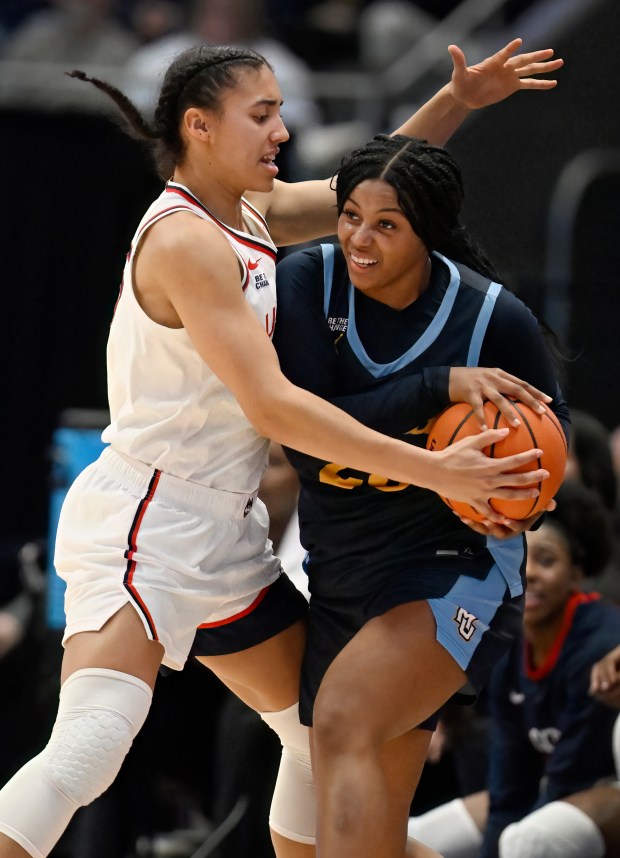 UConn guard Azzi Fudd, left, pressures Marquette guard Olivia Porter, right, in the first half of an NCAA college basketball game, Wednesday, Dec. 17, 2025, in Hartford, Conn. (AP Photo/Jessica Hill)