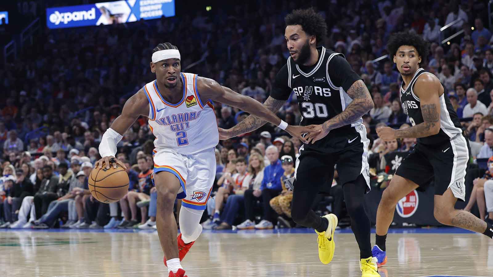 Spurs guard De'Aaron Fox (4) drives to the basket beside Oklahoma City Thunder guard Shai Gilgeous-Alexander (2) during the second quarter at Paycom Center