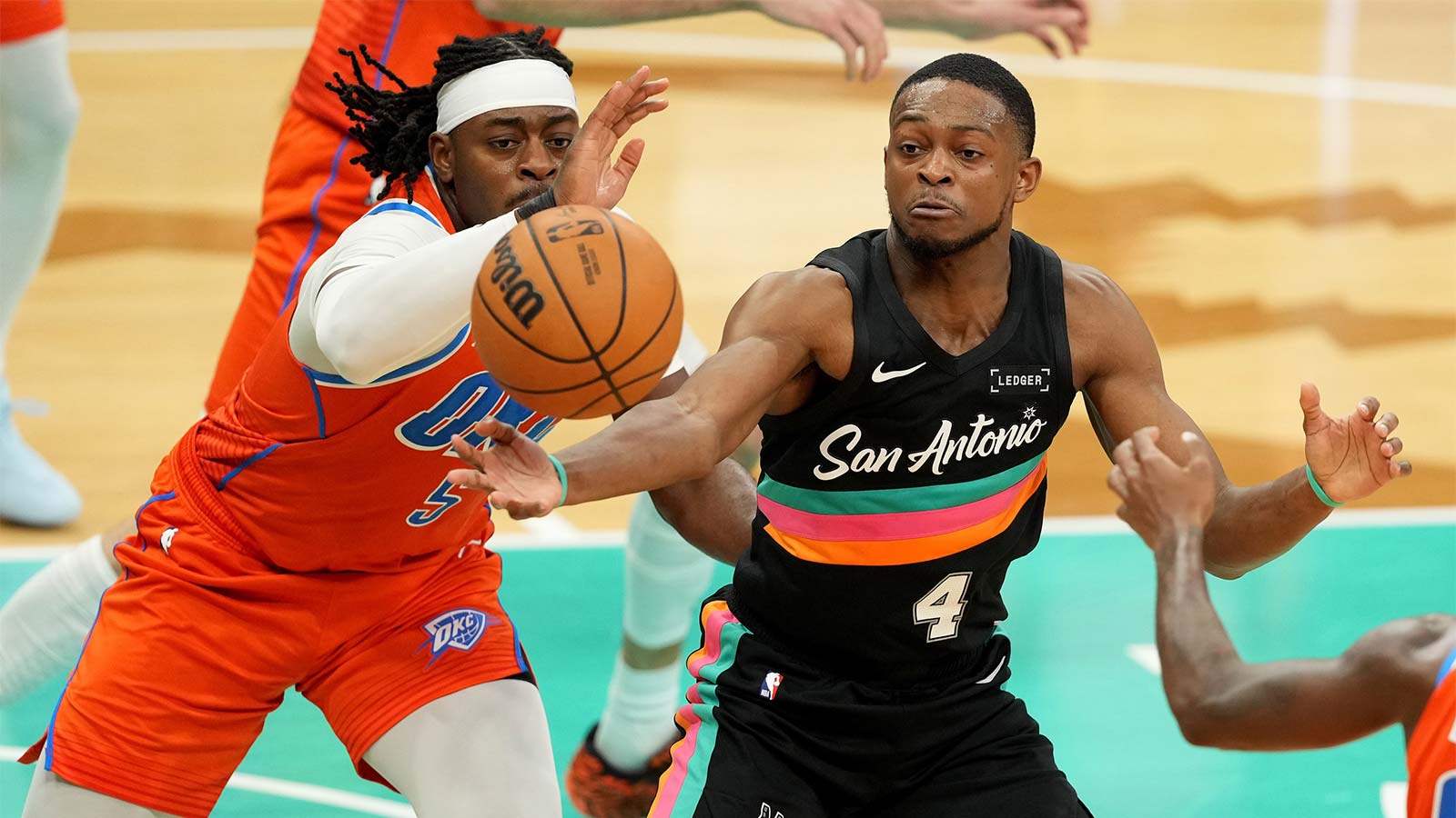 Spurs guard De’Aaron Fox (4) and Oklahoma City Thunder guard Luguentz Dort (5) reach for a loose ball during the first half at Frost Bank Center