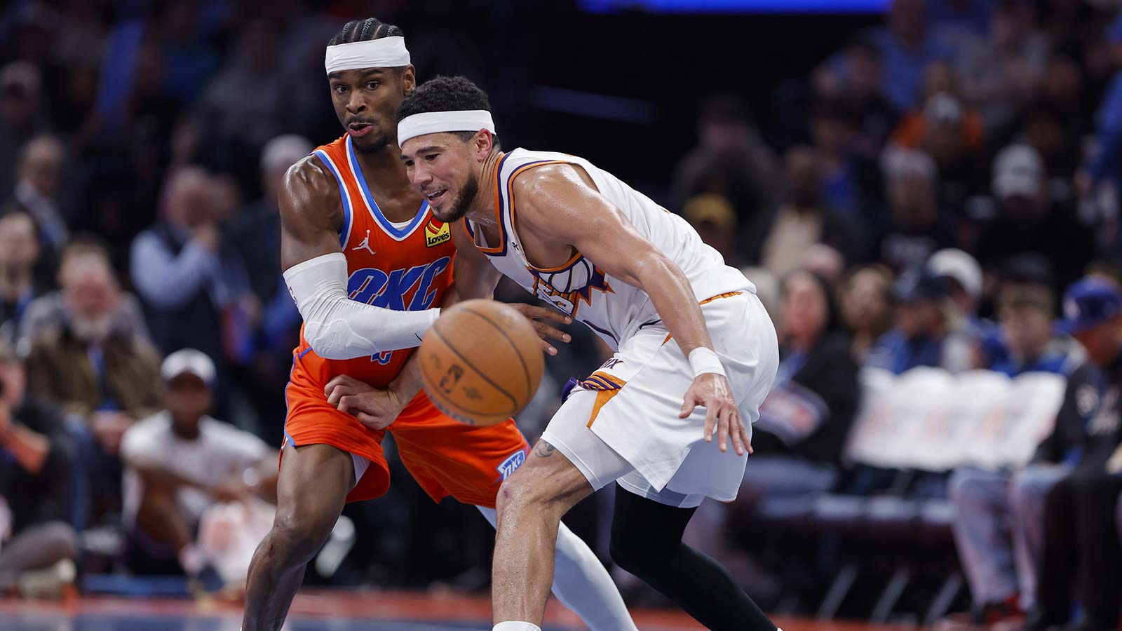 Thunder guard Shai Gilgeous-Alexander (2) forces Phoenix Suns guard Devin Booker (1) to turn over the ball during the second half at Paycom Center
