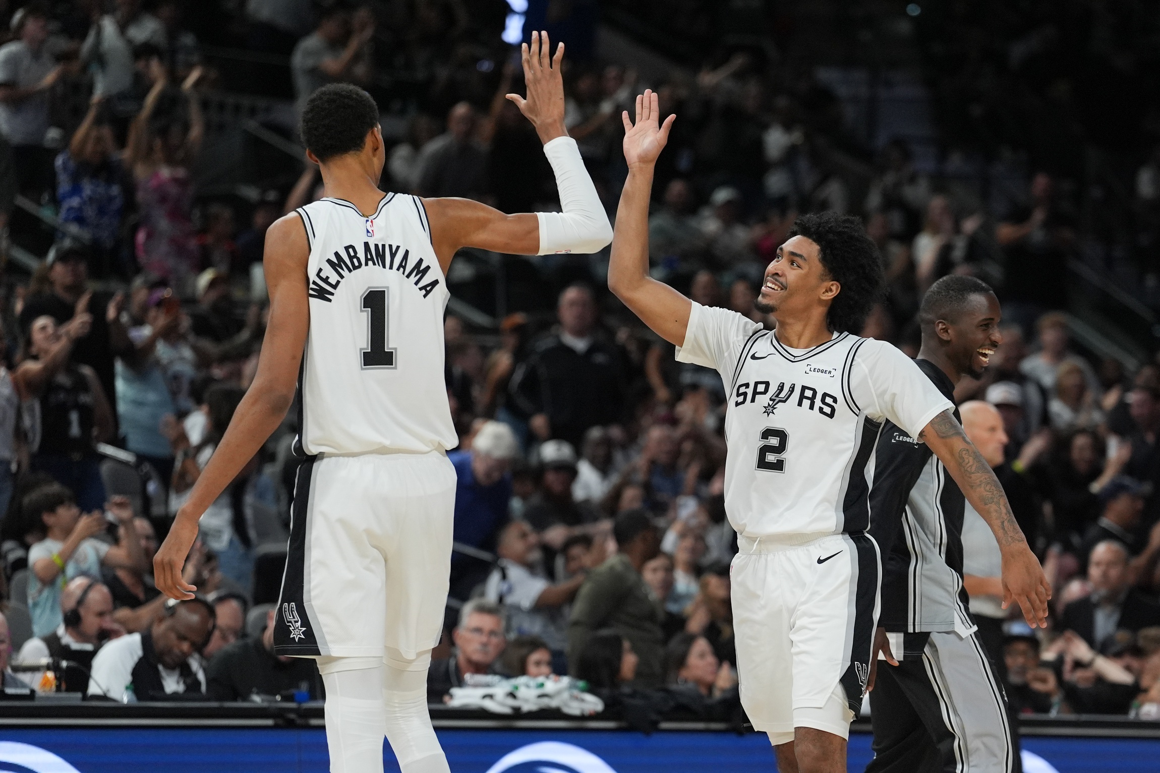 San Antonio Spurs forward Victor Wembanyama (1) and guard Dylan Harper (2) celebrates in the second half against the Brooklyn Nets at Frost Bank Center.