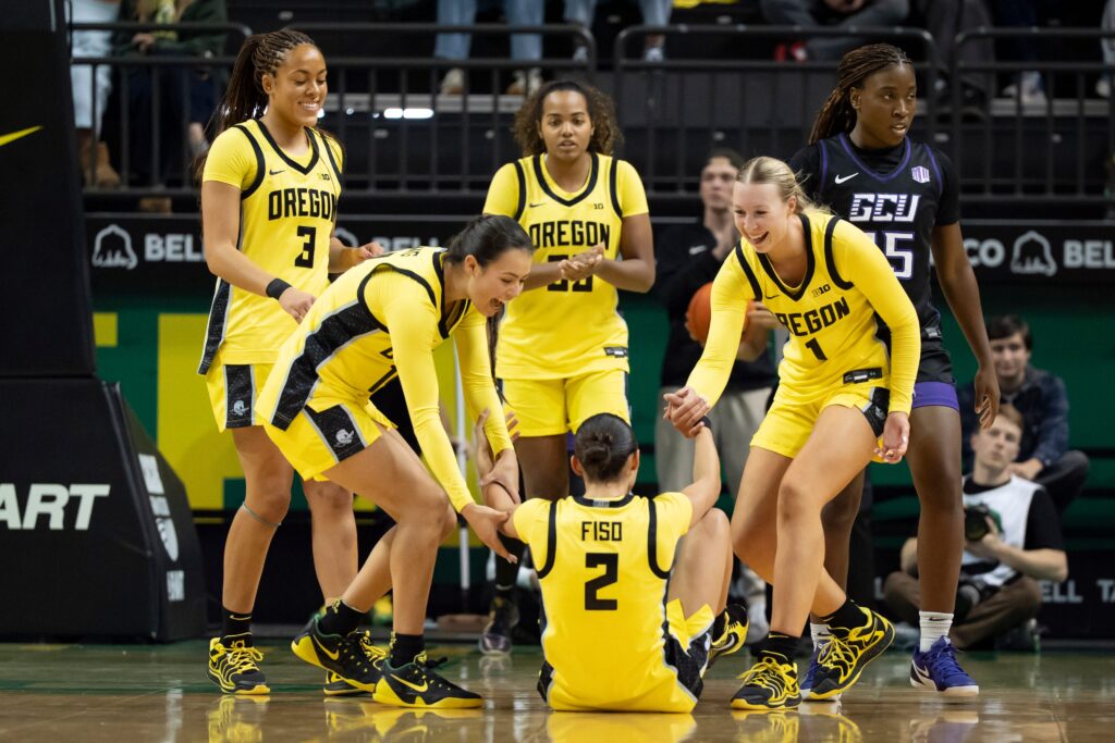 Oregon players help up teammate Katie Fiso