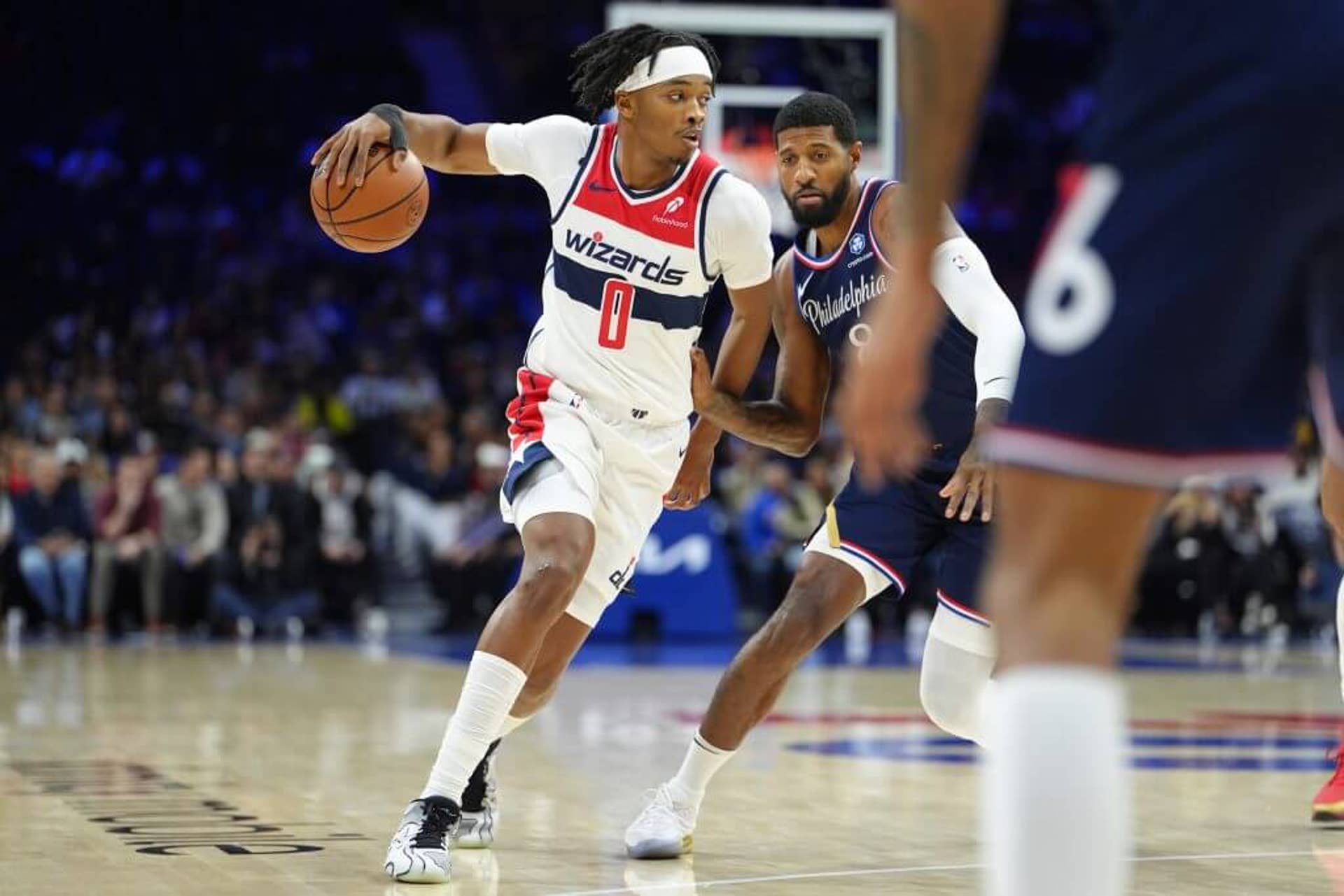 Bilal Coulibaly dribbles past Paul George during a Wizards-76ers game.