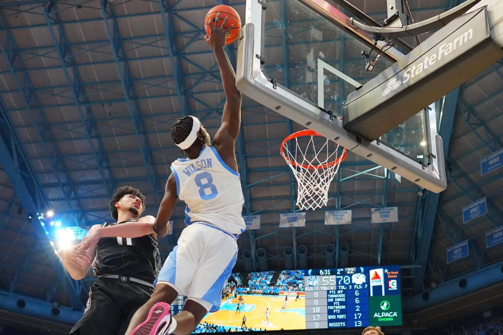 Caleb Wilson, in white jersey, reaches for an alley-oop pass.