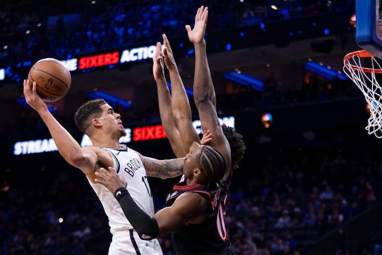 Brooklyn's Michael Porter Jr. (left), is defended by Tyrese Maxey and Joel Embiid during Tuesday night's game.