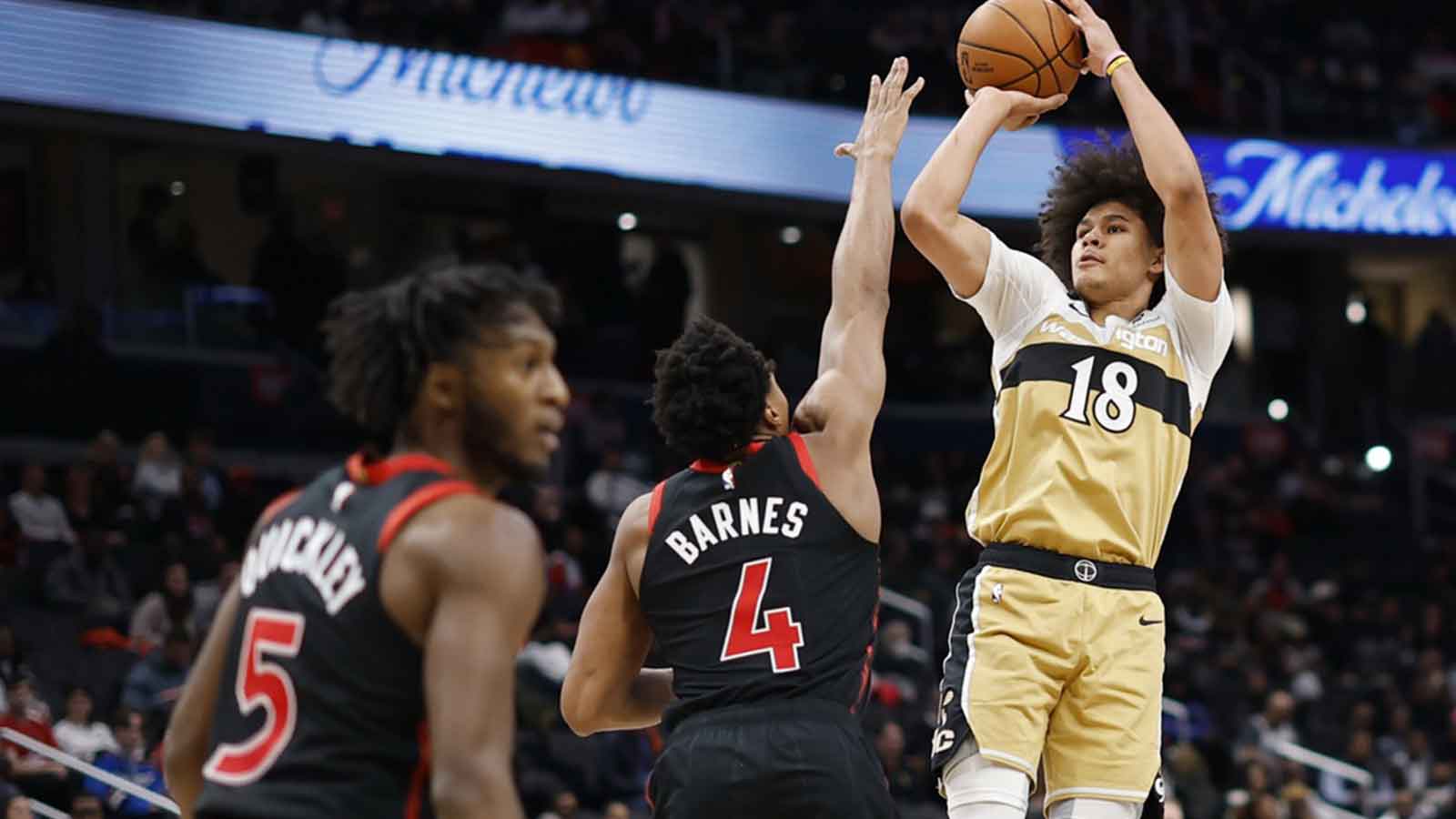 Dec 26, 2025; Washington, District of Columbia, USA; Washington Wizards forward Kyshawn George (18) shoots the ball over Toronto Raptors forward Scottie Barnes (4) in the second half at Capital One Arena.