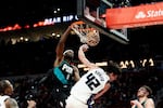 Portland Trail Blazers forward Jerami Grant, left, dunks the ball against Sacramento Kings center Maxime Raynaud, right, during the second half of an NBA basketball game Thursday Dec. 18, 2025, in Portland, Ore.