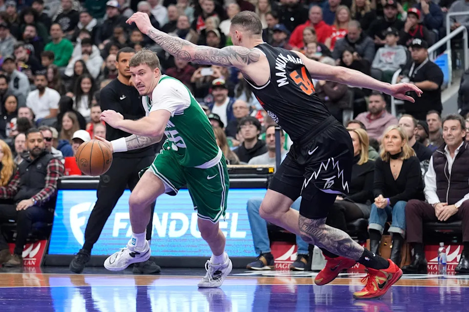 Dec 7, 2025; Toronto, Ontario, CAN; Boston Celtics guard Baylor Scheierman (55) tries to dribble around Toronto Raptors forward Sandro Mamukelashvili (54) during the first half at Scotiabank Arena. Mandatory Credit: John E. Sokolowski-Imagn Images