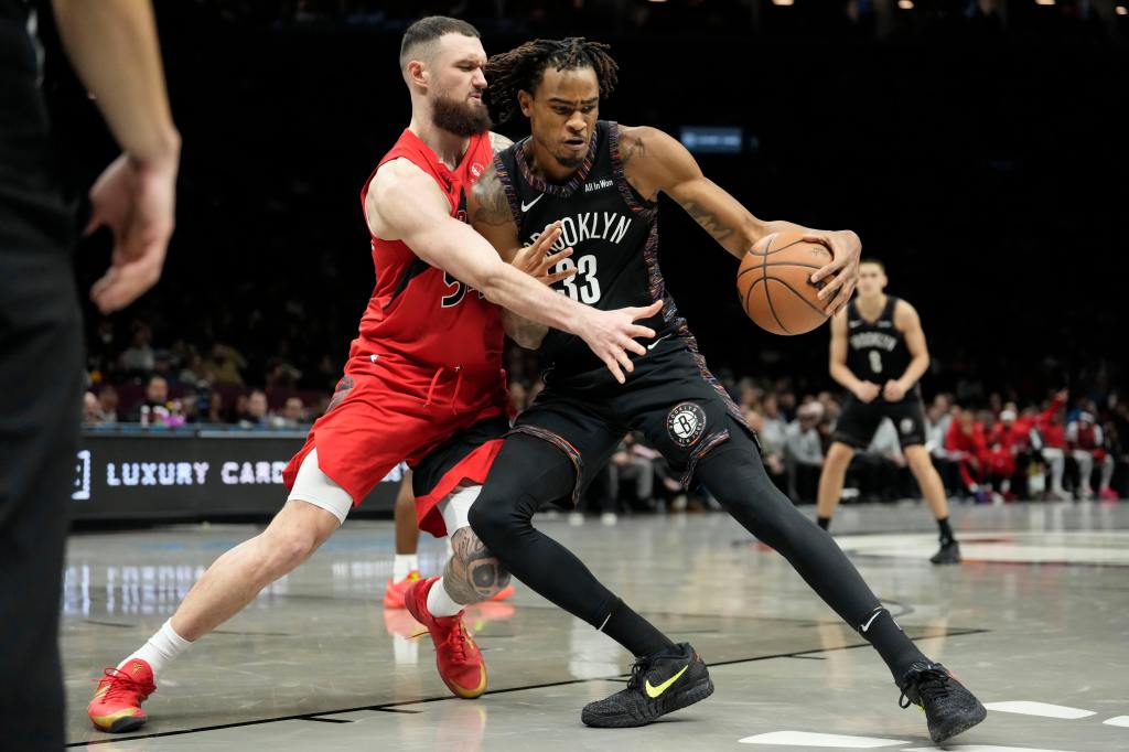 Nic Claxton attempts to drive past Toronto Raptors forward Sandro Mamukelashvili during Dec. 21, 2025 game.