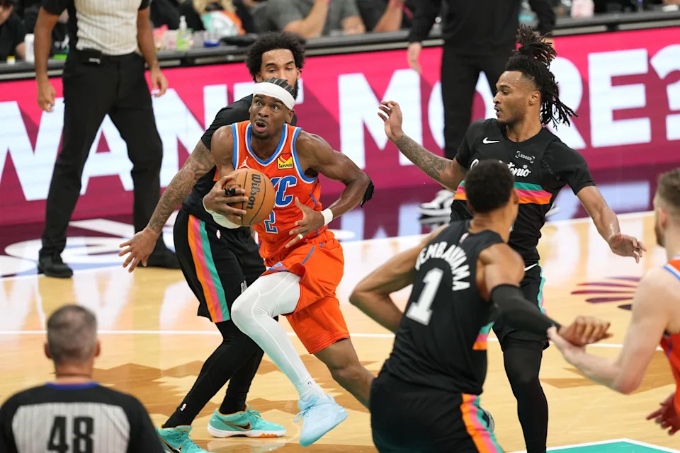 Dec 23, 2025; San Antonio, Texas, USA; Oklahoma City Thunder guard Shai Gilgeous-Alexander (2) drives to the basket past San Antonio Spurs guard Stephon Castle (5) and forward Julian Champagnie (30) during the second half at Frost Bank Center. Mandatory Credit: Scott Wachter-Imagn Images