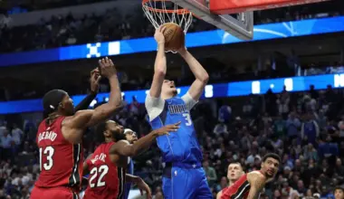 Cooper Flagg of the Dallas Mavericks is defended by Andrew Wiggins and Bam Adebayo of the Miami Heat during the second half at American Airlines Center.