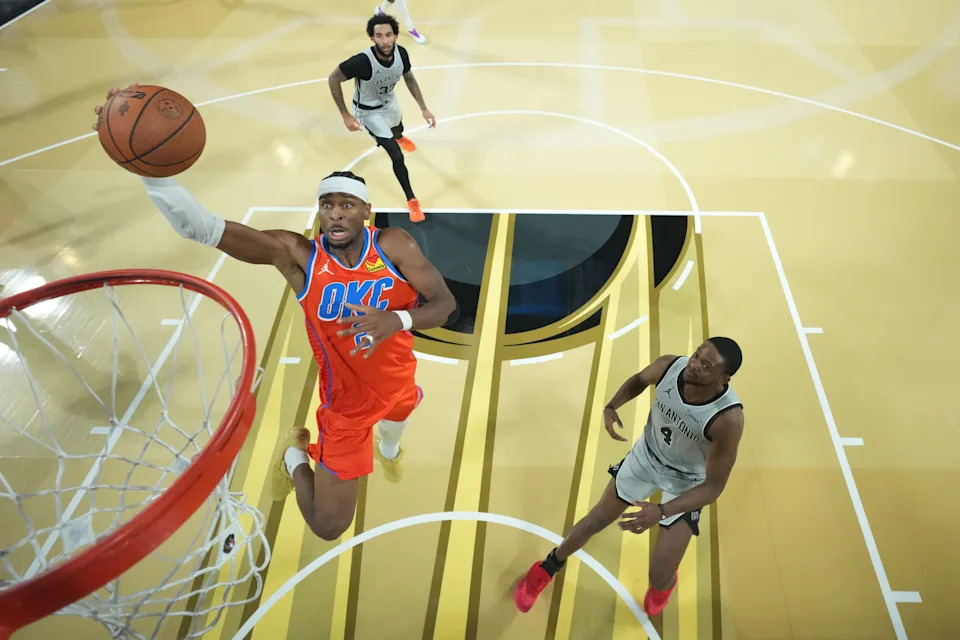 Dec 13, 2025; Las Vegas, Nevada, USA; Oklahoma City Thunder guard Shai Gilgeous-Alexander (2) goes up for the lay up as San Antonio Spurs guard De'Aaron Fox (4) looks on during the second half at T-Mobile Arena. Mandatory Credit: Kirby Lee-Imagn Images