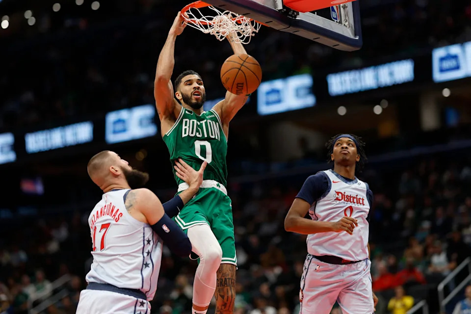 Dec 15, 2024; Washington, District of Columbia, USA; Boston Celtics forward Jayson Tatum (0) dunks the ball as Washington Wizards center Jonas Valanciunas (17) an d Wizards guard Bilal Coulibaly (0) defend in the second quarter at Capital One Arena. Mandatory Credit: Geoff Burke-Imagn Images
