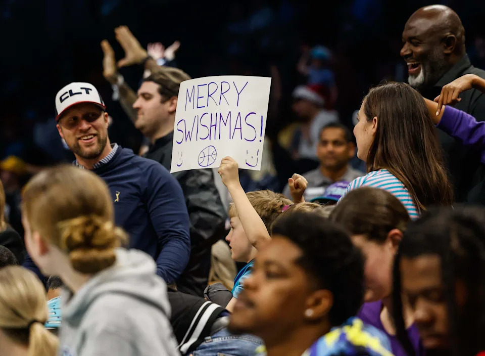 With only two days left until Christmas, a young Hornets fan holds a homemade  “Merry Swishmas” sign during the game against the Wizards on Tuesday at Spectrum Center. Hornets fans received an early gift with a 126-109 win over the Wizards.