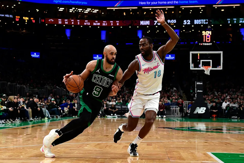 Apr 2, 2025; Boston, Massachusetts, USA; Boston Celtics guard Derrick White (9) controls the ball while Miami Heat guard Alec Burks (18) defends during the second half at TD Garden. Mandatory Credit: Bob DeChiara-Imagn Images