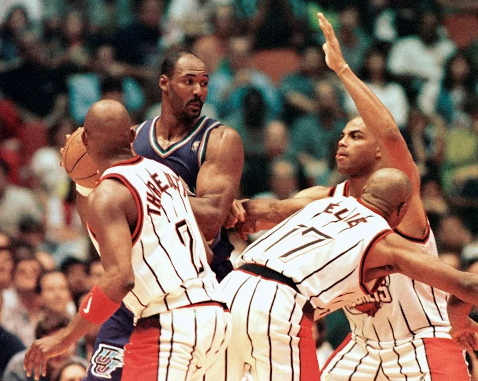 Utah Jazz player Karl Malone (R) is surrounded by Houston Rockets defenders, from left, Sadale Threatt, Mario Ellie and Charles Barkley 25 May during game four of the NBA Western Conference championship at The Summit in Houston, TX. The Jazz lost to the Rockets 95-92. AFP PHOTO/HECTOR MATA (Photo by HECTOR MATA / AFP) (Photo credit should read HECTOR MATA/AFP via Getty Images)