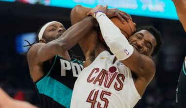 Portland Trail Blazers forward Jerami Grant, left, and Cleveland Cavaliers guard Donovan Mitchell (45) fight for control of the ball in the first half of an NBA basketball game Wednesday, Dec. 3, 2025, in Cleveland. (AP Photo/Sue Ogrocki)