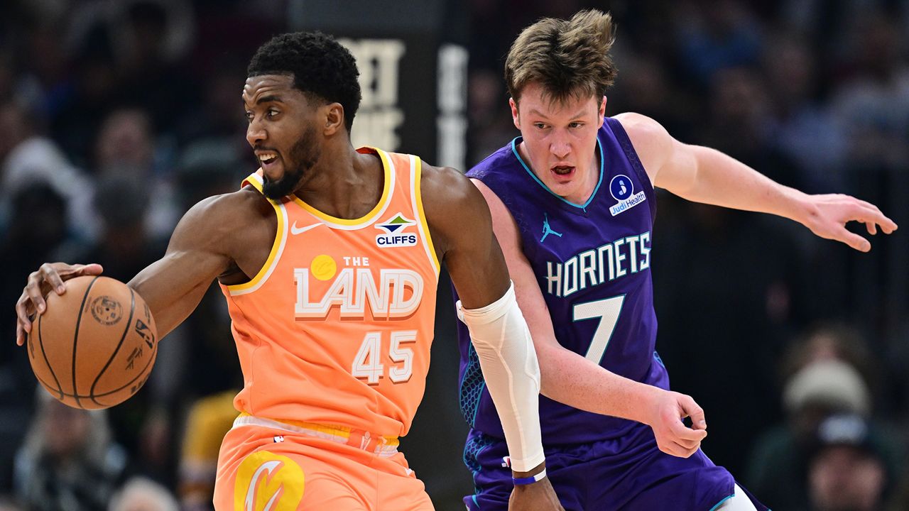 Cleveland Cavaliers guard Donovan Mitchell (45) spins around Charlotte Hornets guard Kon Knueppel (7) in the first half of an NBA basketball game, Monday, Dec. 22, 2025, in Cleveland. (AP Photo/David Dermer)