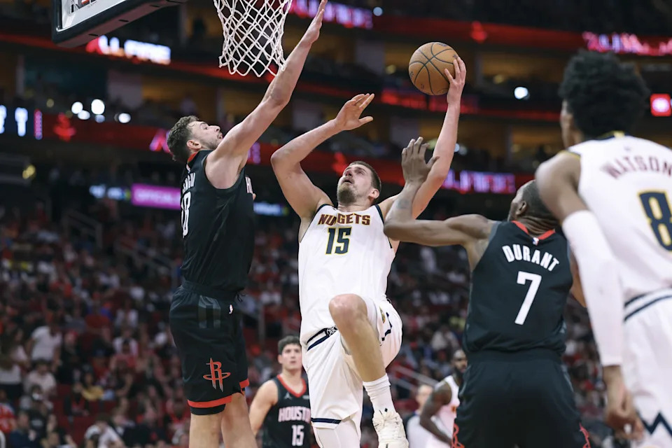 Nov 21, 2025; Houston, Texas, USA; Denver Nuggets center Nikola Jokic (15) shoots the ball as Houston Rockets center Alperen Sengun (28) defends during the fourth quarter at Toyota Center. Mandatory Credit: Troy Taormina-Imagn Images