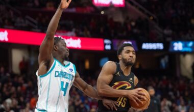 Cleveland Cavaliers' Donovan Mitchell (45) keeps the ball away from Charlotte Hornets' Sion James (4) during the second half of an NBA basketball game in Cleveland, Sunday, Dec. 14, 2025. (AP Photo/Phil Long)