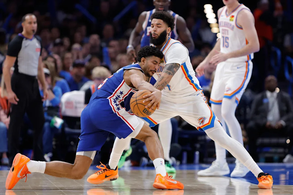 Dec 28, 2025; Oklahoma City, Oklahoma, USA; Philadelphia 76ers guard Quentin Grimes (5) is defended by Oklahoma City Thunder guard Kenrich Williams (34) during a drive in the second half at Paycom Center. Mandatory Credit: Alonzo Adams-Imagn Images