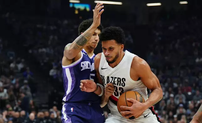 Portland Trail Blazers forward Toumani Camara (33) tries to drive past Sacramento Kings guard Nique Clifford (5) during the first half of an NBA basketball game Saturday, Dec. 20, 2025, in Sacramento, Calif. (AP Photo/Alan Greth)