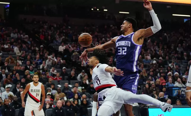 Sacramento Kings center Dylan Cardwell (32) and Portland Trail Blazers guard Shaedon Sharpe (17) fight for the ball during the first half of an NBA basketball game Saturday, Dec. 20, 2025, in Sacramento, Calif. (AP Photo/Alan Greth)