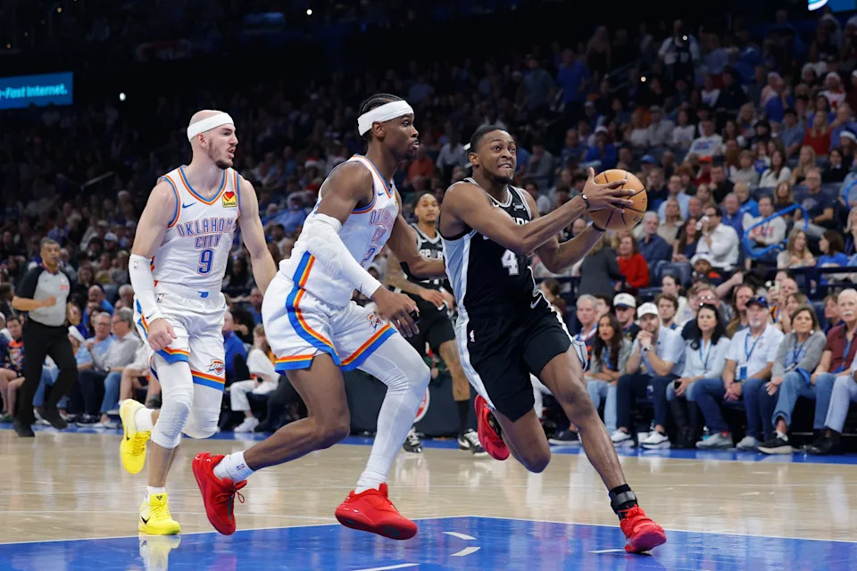 Dec 25, 2025; Oklahoma City, Oklahoma, USA; San Antonio Spurs guard De'Aaron Fox (4) drives to the basket beside Oklahoma City Thunder guard Shai Gilgeous-Alexander (2) during the second quarter at Paycom Center. Mandatory Credit: Alonzo Adams-Imagn Images
