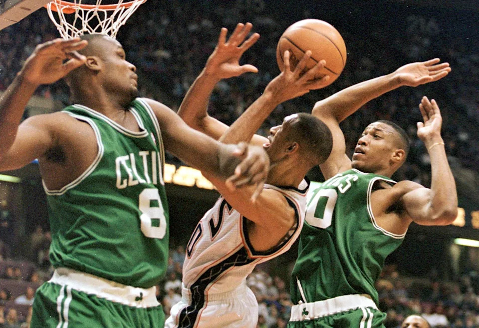 New Jersey Nets guard Kerry Kittles (C) is fouled as he drives between Boston Celtics players Antoine Walker (L) and Tony Battie (R) in the second quarter 27 February at Continental Airlines Arena in East Rutherford, N.J. AFP PHOTO/Matt CAMPBELL (Photo by MATT CAMPBELL / AFP)  (Photo credit should read MATT CAMPBELL/AFP via Getty Images)
