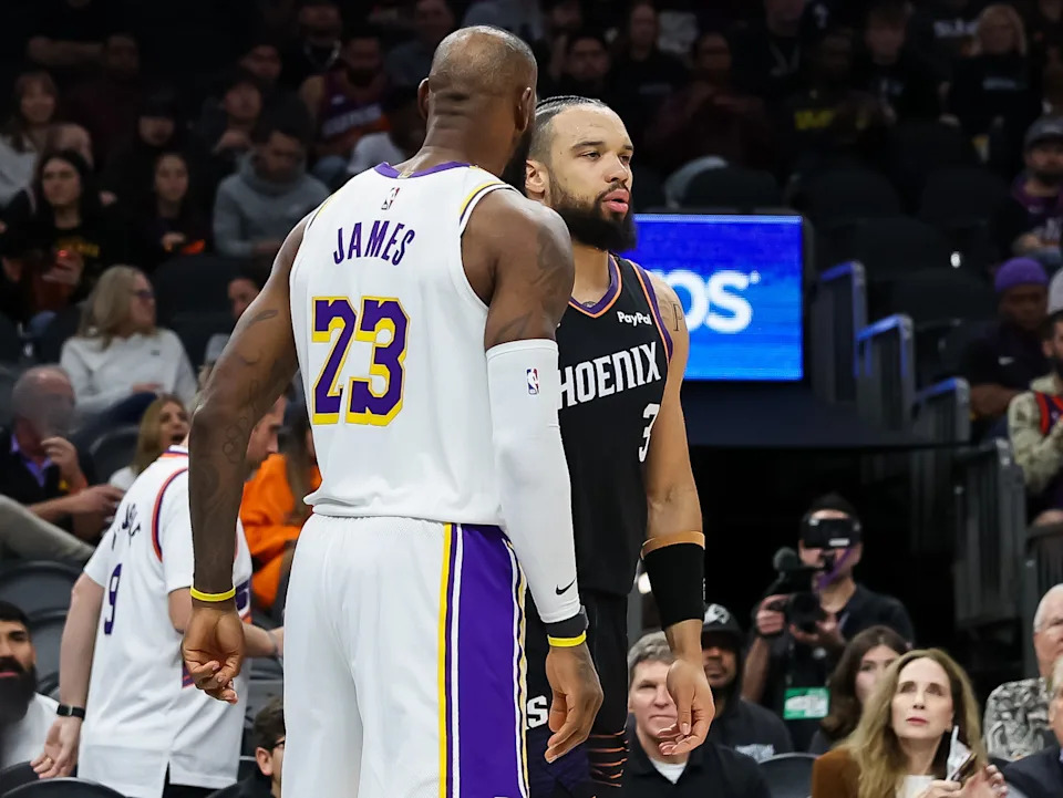 Lebron James #23 of the Los Angeles Lakers and Dillon Brooks #3 of the Phoenix Suns get together after a play during the second half of a game at Mortgage Matchup Center on Dec. 14, 2025, in Phoenix.