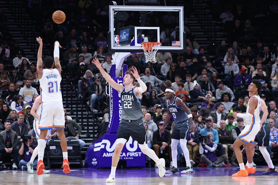 Dec 7, 2025; Salt Lake City, Utah, USA; Oklahoma City Thunder guard Aaron Wiggins (21) shoots a three-point shot against Utah Jazz forward Kyle Filipowski (22) during the second half at Delta Center. Mandatory Credit: Rob Gray-Imagn Images