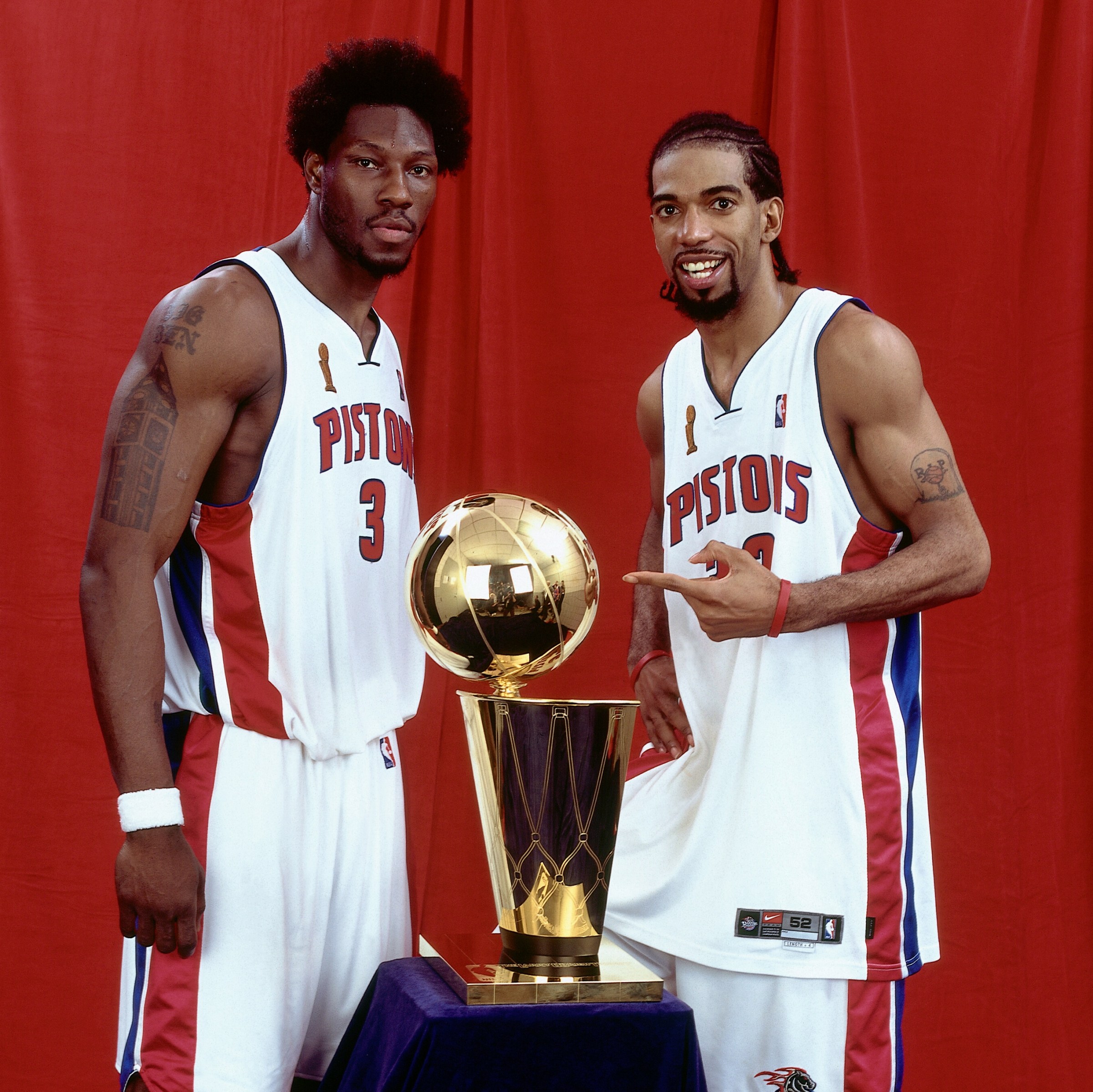 AUBURN HILLS, MI - JUNE 15: Ben Wallace #3 and Richard Hamilton #32 of the Detroit Pistons pose with the Championship trophy after Game Five of the 2004 NBA Finals on June 15, 2004 at The Palace of Auburn Hills in Auburn Hills, Michigan. NOTE TO USER: User expressly acknowledges and agrees that, by downloading and/or using this Photograph, User is consenting to the terms and conditions of the Getty Images License Agreement. Mandatory Copyright Notice: Copyright 2004 NBAE. (Photo by Andrew D. Bernstein/NBAE via Getty Images)