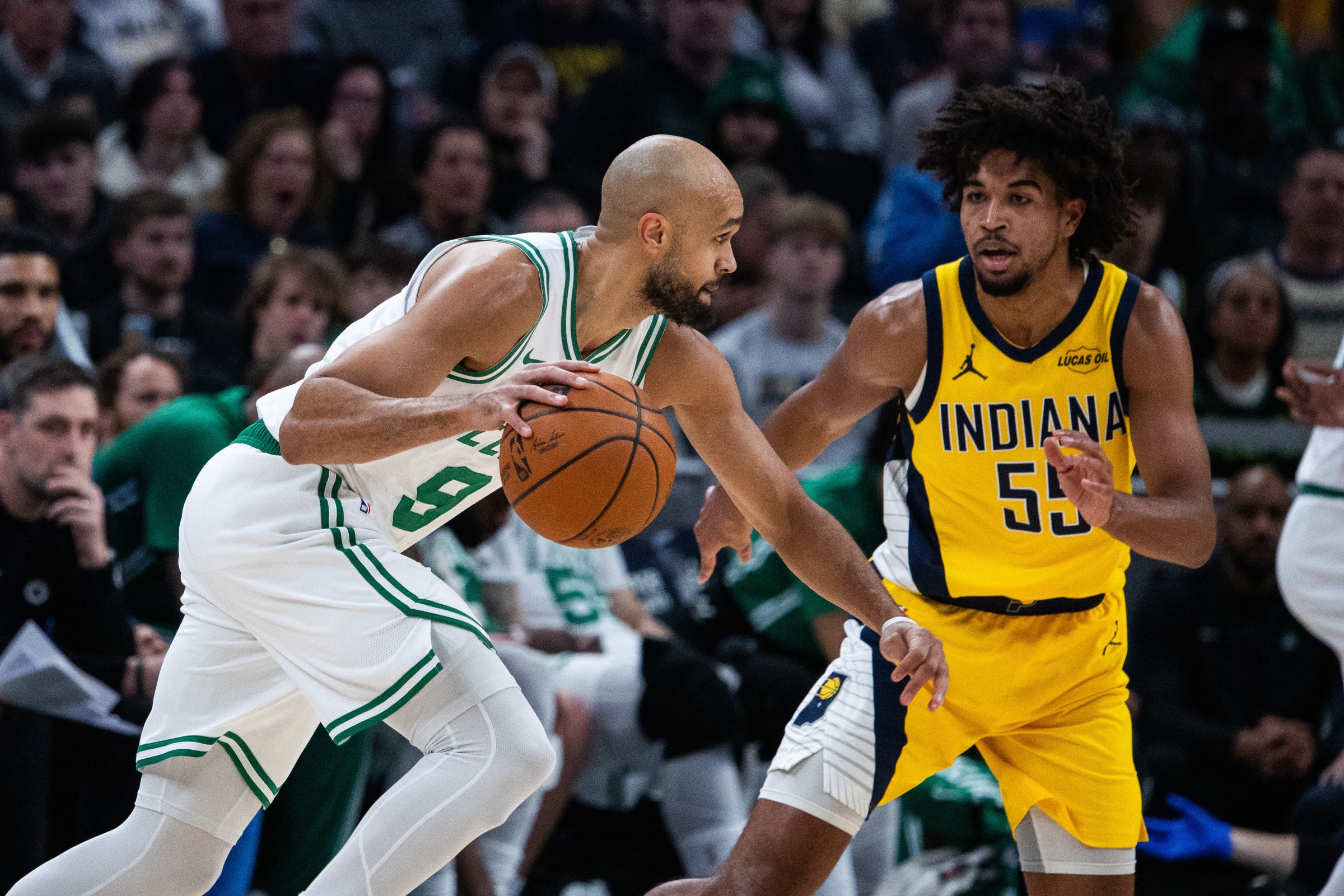 Dec 26, 2025; Indianapolis, Indiana, USA; Boston Celtics guard Derrick White (9) dribbles the ball while Indiana Pacers guard Ethan Thompson (55) defends in the first half at Gainbridge Fieldhouse. Mandatory Credit: Trevor Ruszkowski-Imagn Images