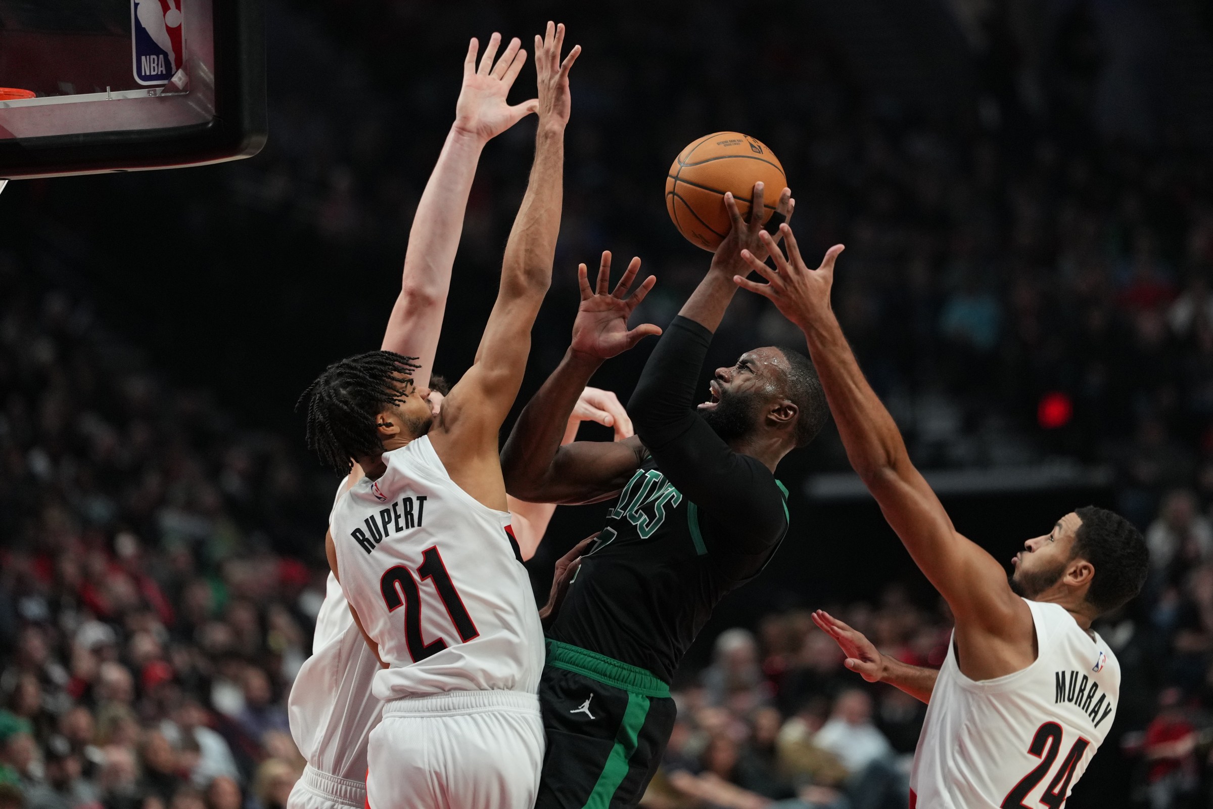 Dec 28, 2025; Portland, Oregon, USA; Boston Celtics guard Jaylen Brown (7) goes up for a shot under pressure from under pressure from Portland Trail Blazers center Donovan Clingan (23), guard Rayan Rupert (21), and forward Kris Murray (24) during the first half at Moda Center. Mandatory Credit: Soobum Im-Imagn Images